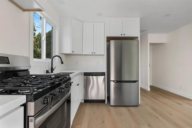 a kitchen with a refrigerator stove and wooden cabinets