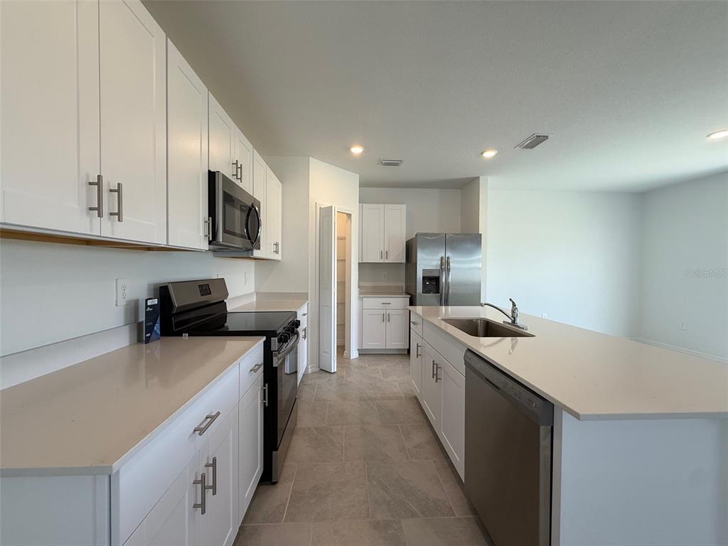 11795 Cloverly Lane Punta Gorda, FL 33955 - Photo 11 of 36 a kitchen with stainless steel appliances a sink stove refrigerator and cabinets
