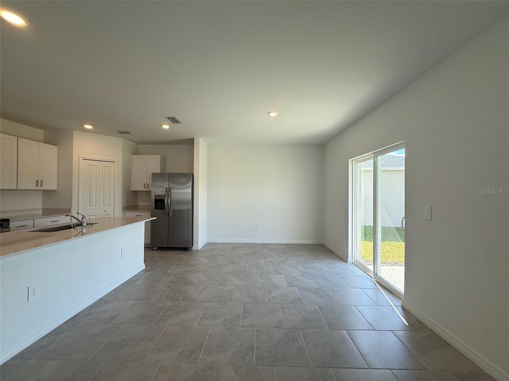 11795 Cloverly Lane Punta Gorda, FL 33955 - Photo 12 of 36 a large kitchen with a stove a refrigerator a sink a microwave and cabinets