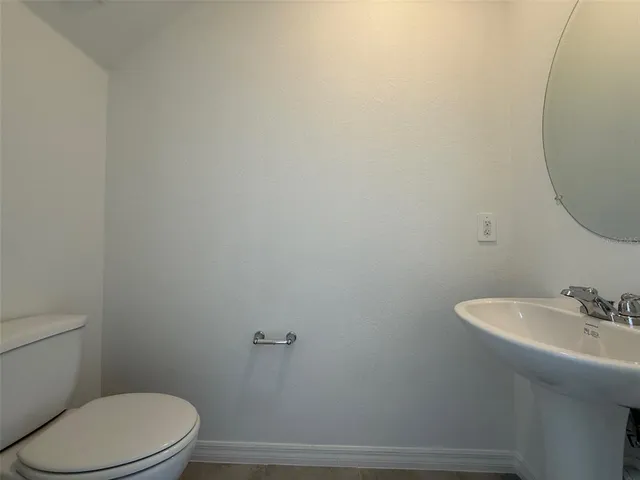 a bathroom with a sink mirror and toilet