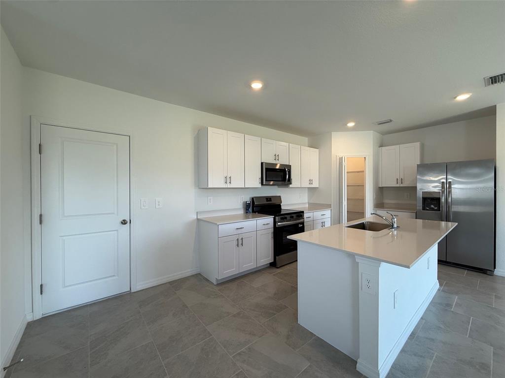 11795 Cloverly Lane Punta Gorda, FL 33955 - Photo 7 of 36 a kitchen that has a lot of white cabinets and stainless steel appliances