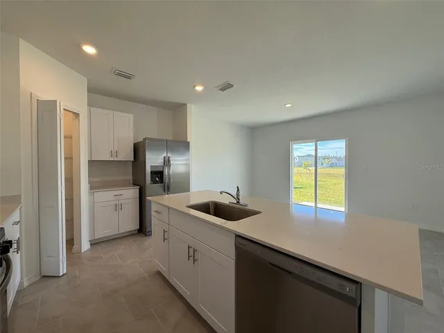 a kitchen that has a sink a refrigerator and window