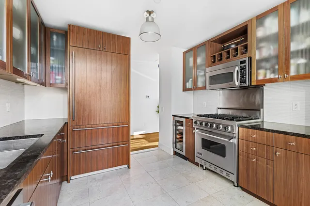a kitchen with stainless steel appliances granite countertop a stove a sink and a refrigerator