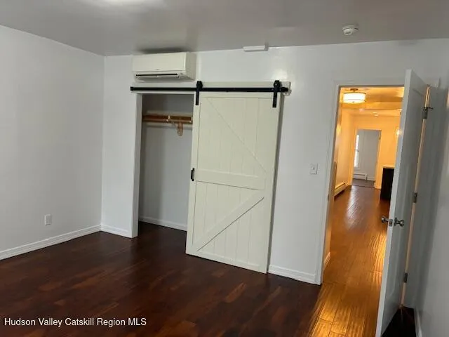 an empty room with wooden floor and a bathroom