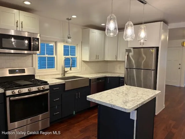 a kitchen with a sink a stove a refrigerator and cabinets