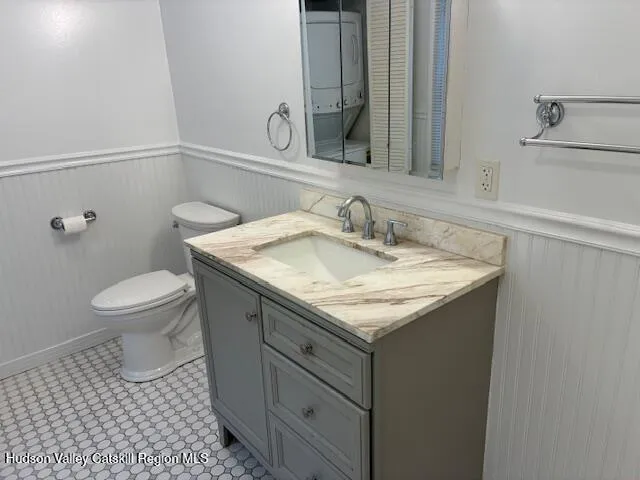 a bathroom with a granite countertop sink a toilet and a mirror