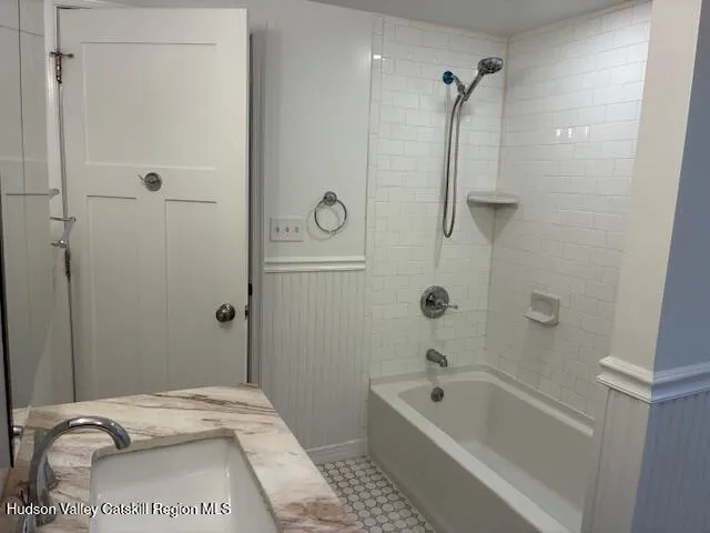 a bathroom with a tub a sink and a shower