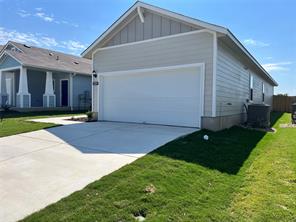 13309 Riding Drive Manor, TX 78653 - Photo 2 of 34 View of front facade featuring board and batten siding, concrete driveway, a garage, and a front lawn