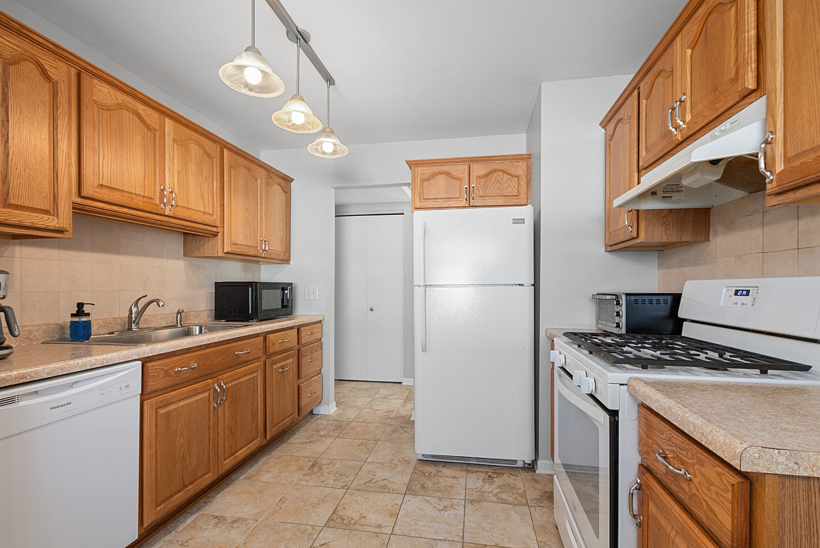 8 Warwick Court Streamwood, IL 60107 - Photo 5 of 14 a kitchen with stainless steel appliances granite countertop a refrigerator a sink dishwasher a stove and white cabinets with wooden floor