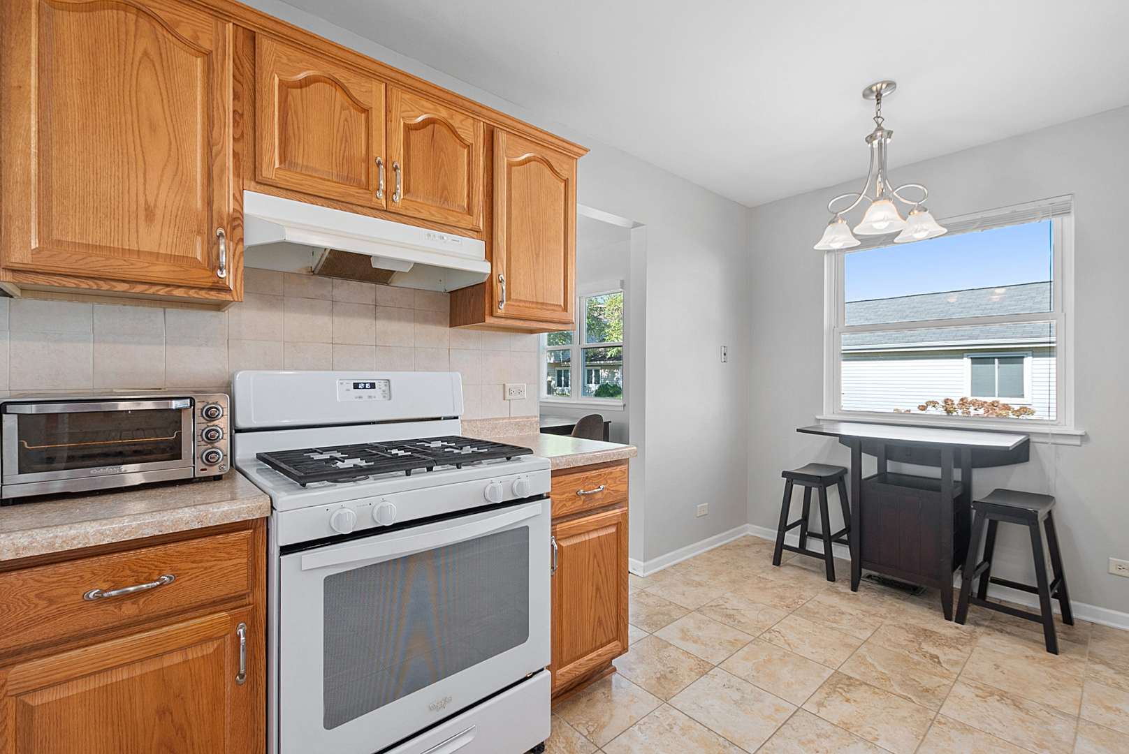 8 Warwick Court Streamwood, IL 60107 - Photo 6 of 14 a kitchen with stainless steel appliances granite countertop wooden cabinets a stove a sink and a window