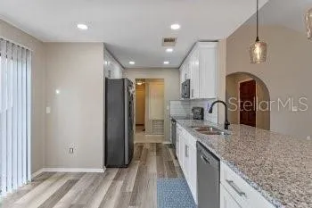 a kitchen with stainless steel appliances granite countertop a stove a sink and a microwave