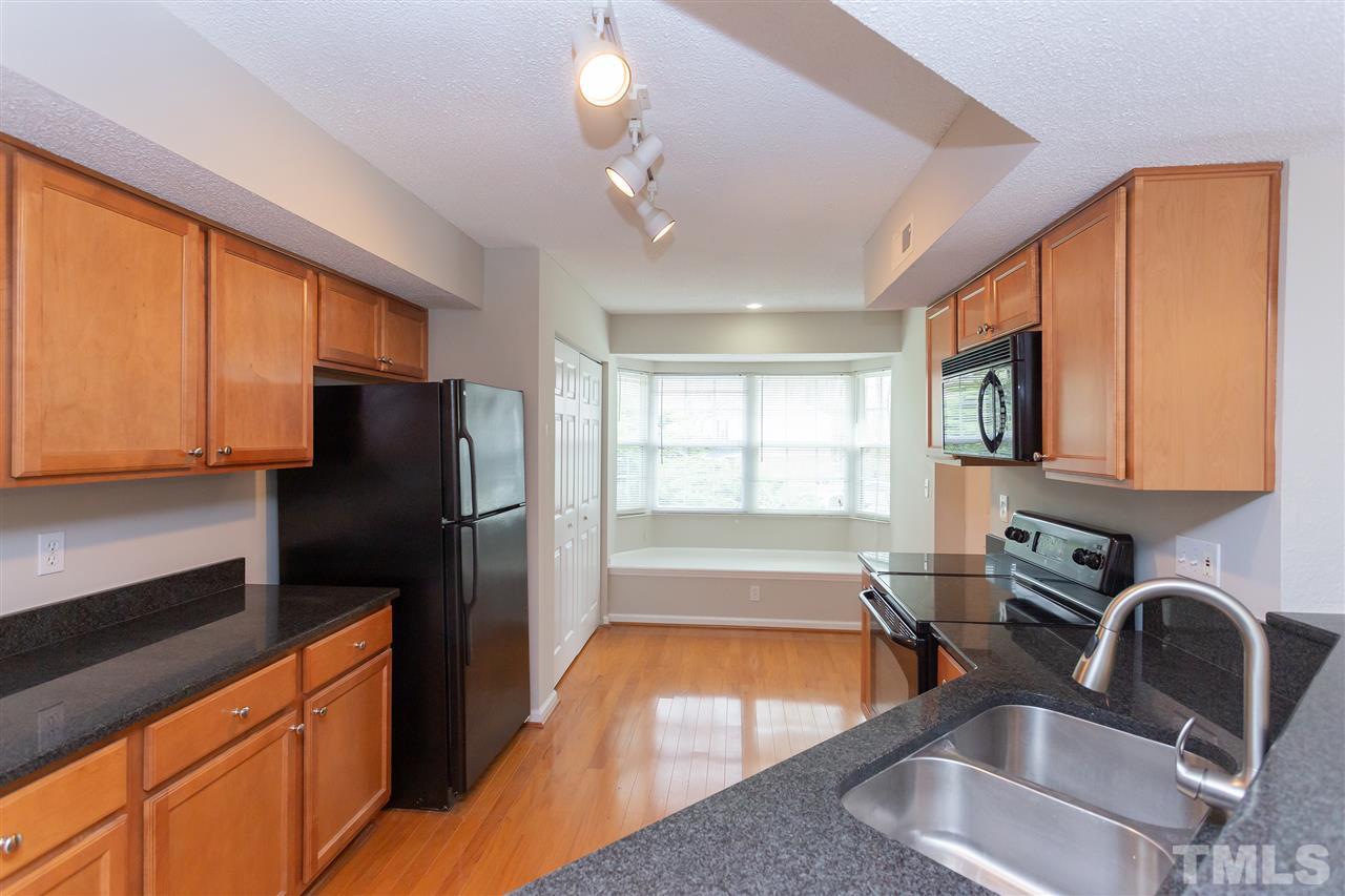 7812 Falcon Rest Circle Raleigh, NC 27615 - Photo 11 of 26 a kitchen with stainless steel appliances granite countertop a sink stove and refrigerator