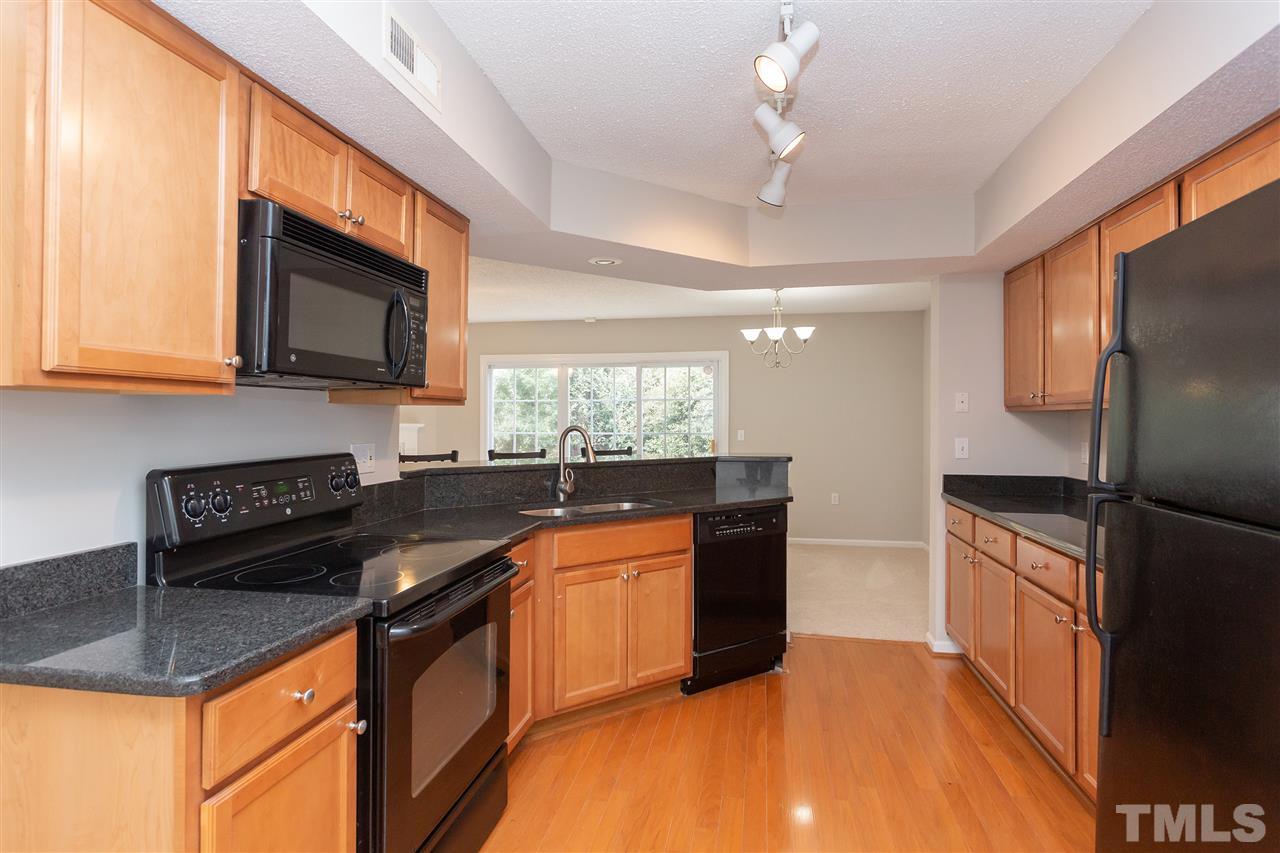 7812 Falcon Rest Circle Raleigh, NC 27615 - Photo 12 of 26 a kitchen with granite countertop a sink stove and refrigerator