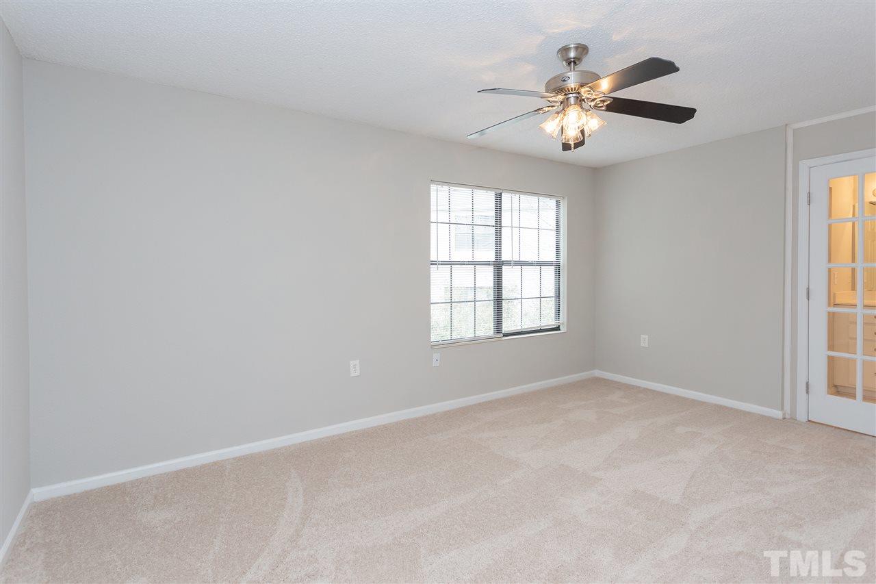 7812 Falcon Rest Circle Raleigh, NC 27615 - Photo 18 of 26 an empty room with windows and chandelier fan