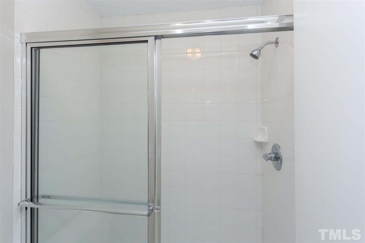 7812 Falcon Rest Circle Raleigh, NC 27615 - Photo 20 of 26 a bathroom with a glass shower door