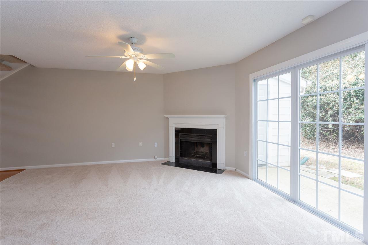 7812 Falcon Rest Circle Raleigh, NC 27615 - Photo 7 of 26 a view of an empty room with chandelier fan and fire place