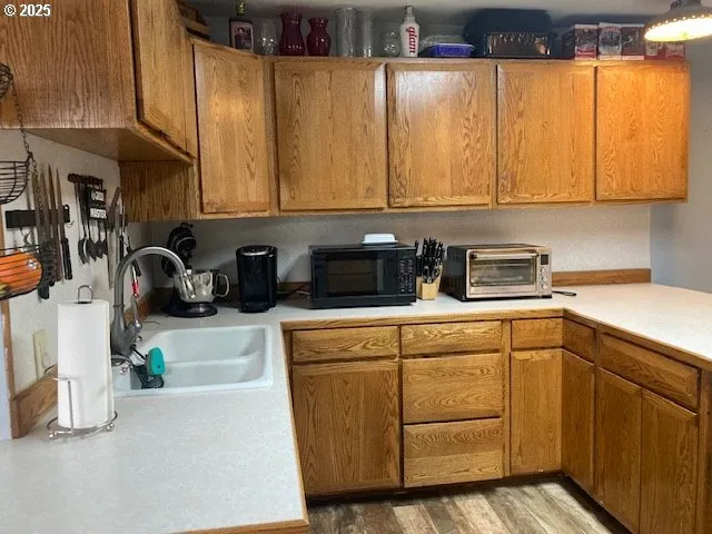 a kitchen with stainless steel appliances kitchen island a table chairs in it and wooden floors