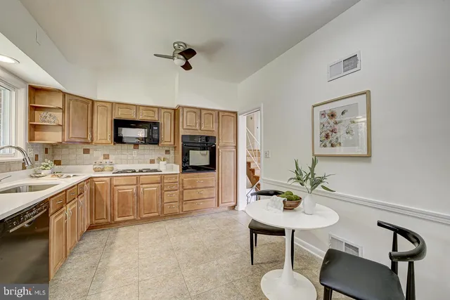 a kitchen with a table chairs sink and cabinets
