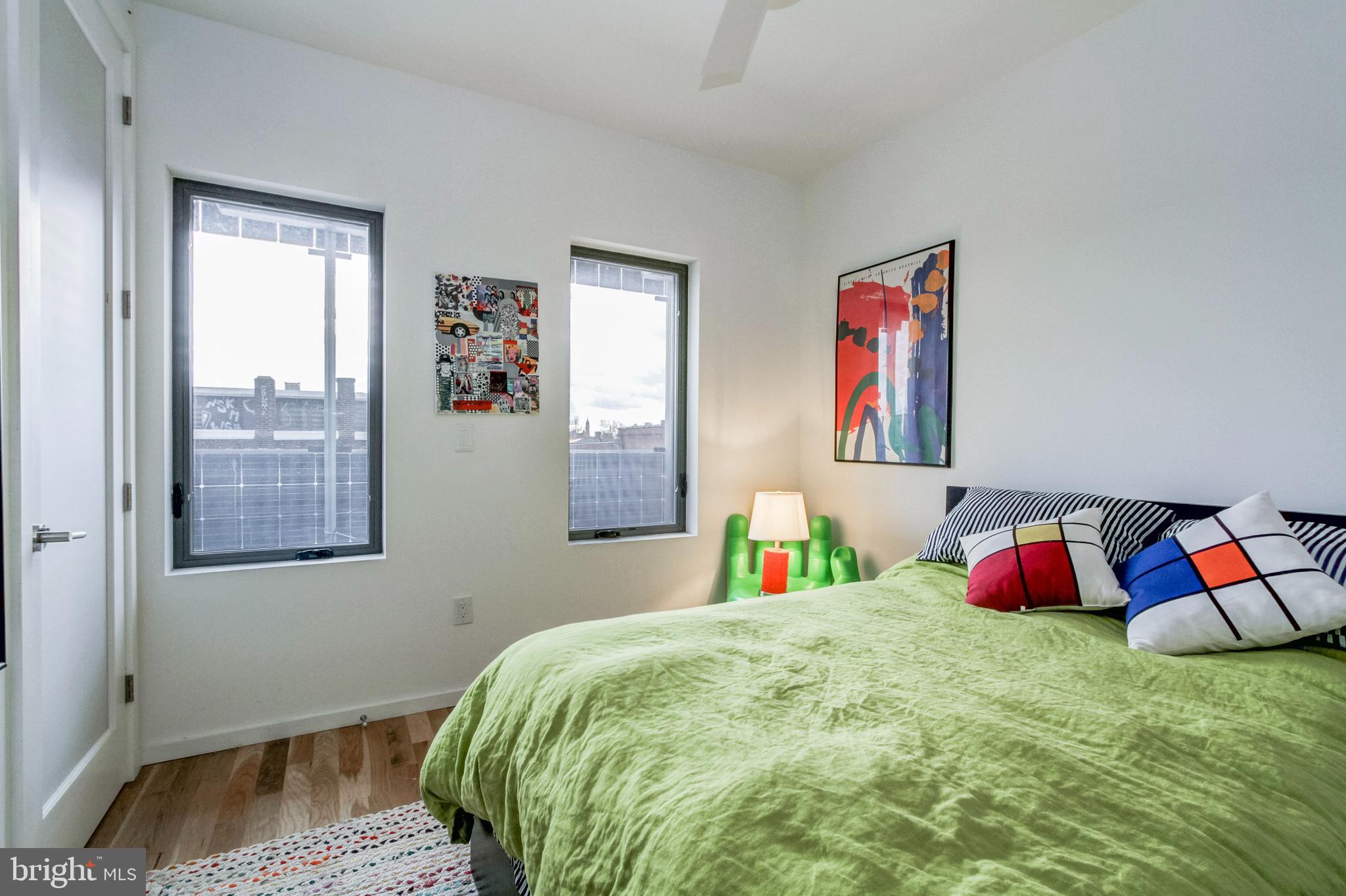 1942 North Front Street, Unit 206 Philadelphia, PA 19122 - Photo 13 of 14 a bed room with a bed and a painting on the wall