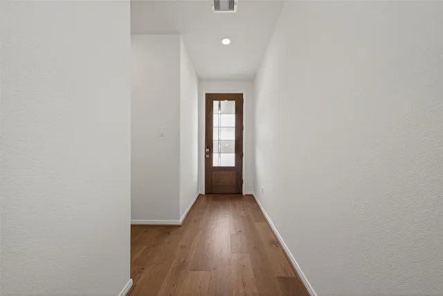 a view of a hallway with wooden floor