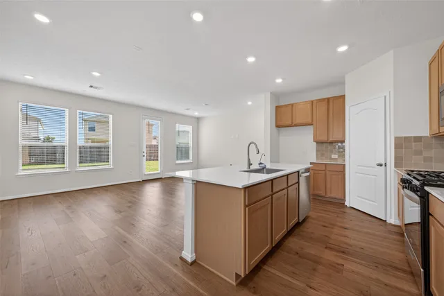 a kitchen with wooden floors and cabinets