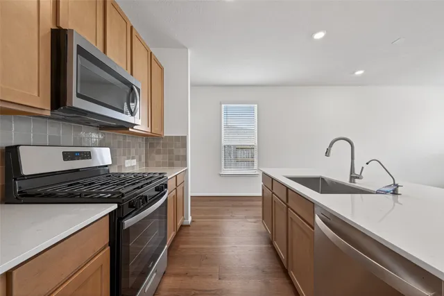 a kitchen with stainless steel appliances a sink stove and cabinets