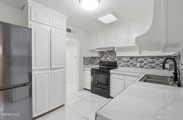 a kitchen with stainless steel appliances a refrigerator sink and stove