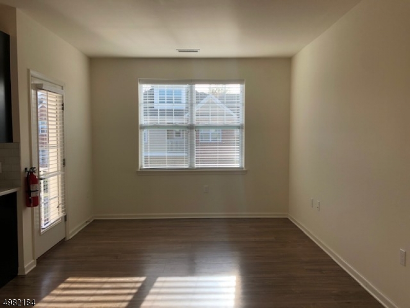 60 Passaic Avenue, Unit 22 Fairfield, NJ 07004 - Photo 2 of 13 an empty room with wooden floor and windows