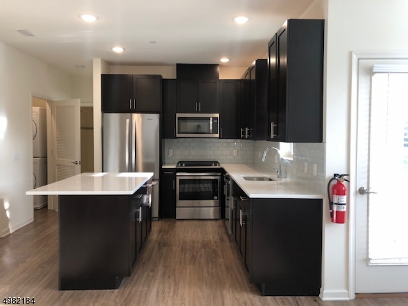 60 Passaic Avenue, Unit 22 Fairfield, NJ 07004 - Photo 3 of 13 a kitchen with kitchen island stainless steel appliances a sink stove and refrigerator
