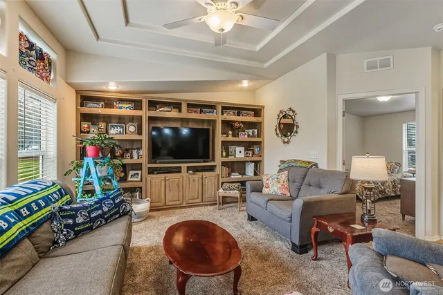 a living room with furniture a flat screen tv and a floor to ceiling window