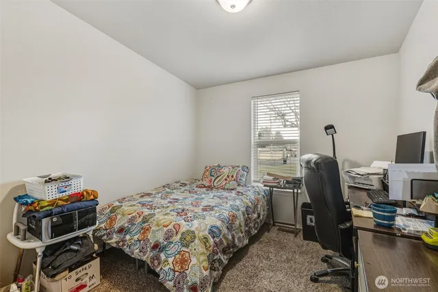 a bedroom with a bed and a computer on a desk