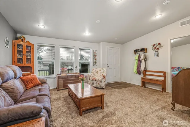 a living room with furniture a large window and a flat screen tv