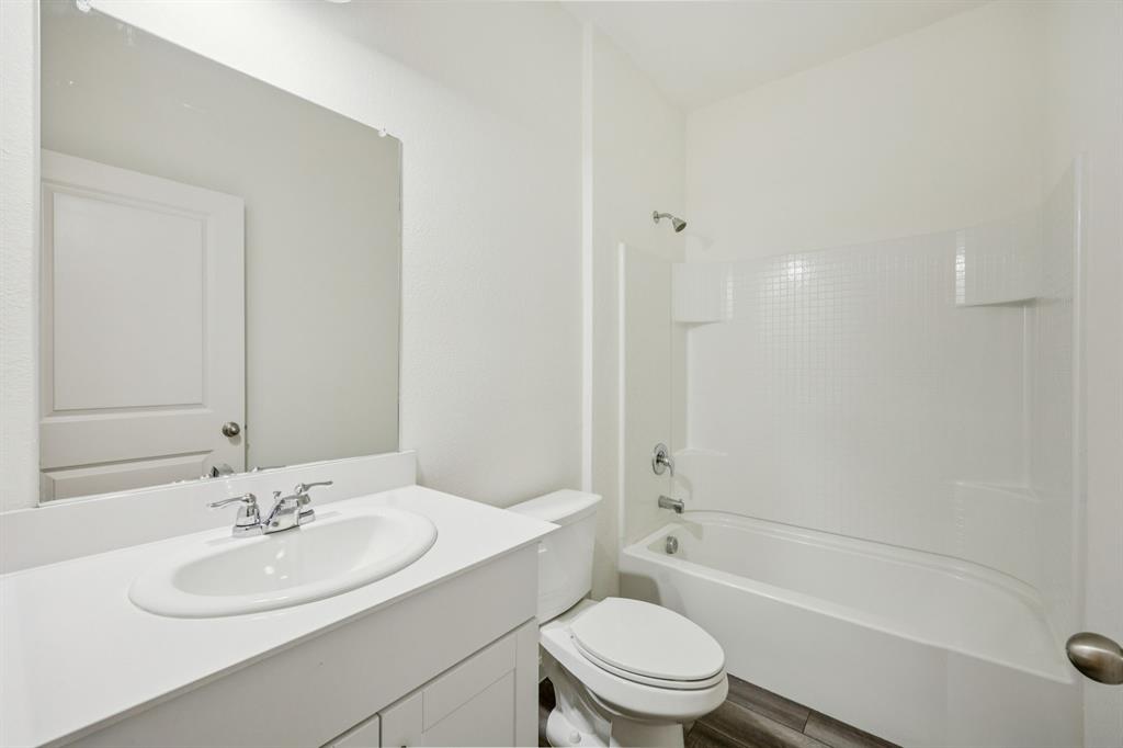 1902 Marquette Road Princeton, TX 75407 - Photo 13 of 30 a bathroom with a granite countertop sink a toilet and shower