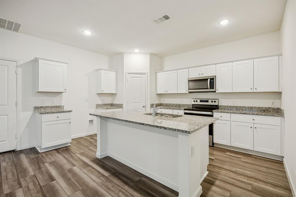 1902 Marquette Road Princeton, TX 75407 - Photo 7 of 30 a kitchen with granite countertop white cabinets sink and stainless steel appliances