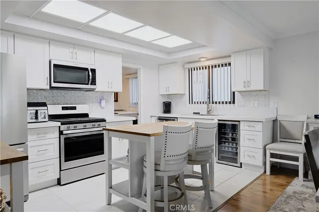 a kitchen with stainless steel appliances granite countertop a stove top oven a sink dishwasher and white cabinets