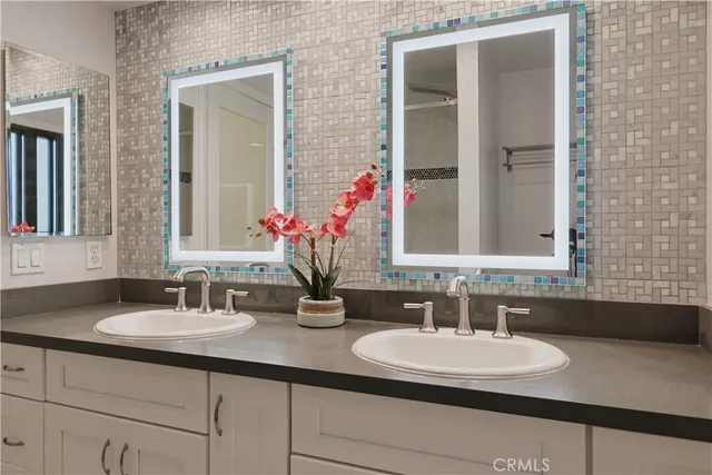 a bathroom with double sink and a mirror