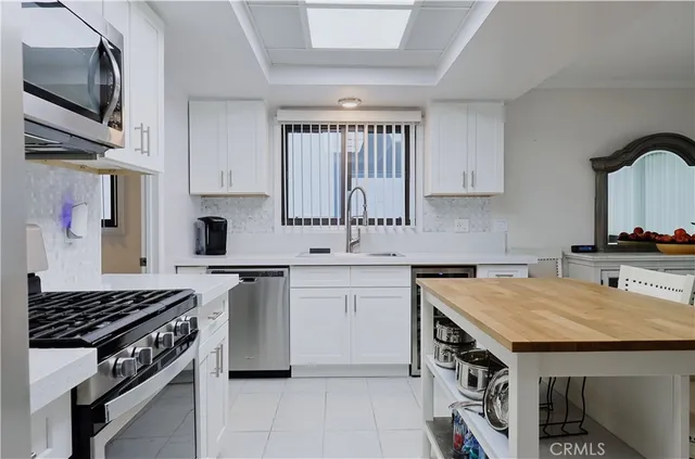 a kitchen with stainless steel appliances a sink stove and cabinets