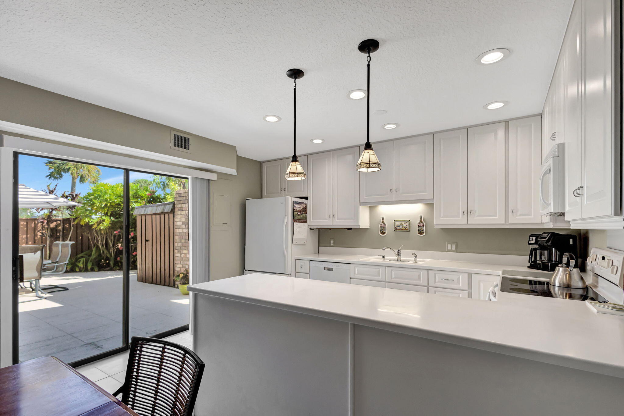 1420 Ocean Way, Unit 23B Jupiter, FL 33477 - Photo 7 of 29 a kitchen with kitchen island a large counter top space appliances and a counter top space