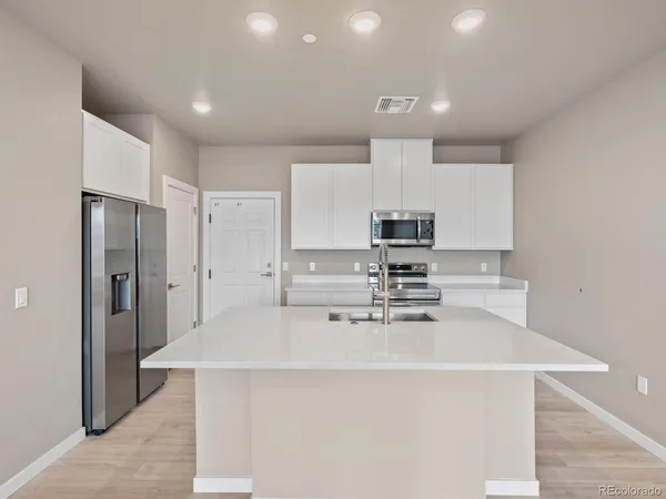 a kitchen with stainless steel appliances a refrigerator sink and microwave