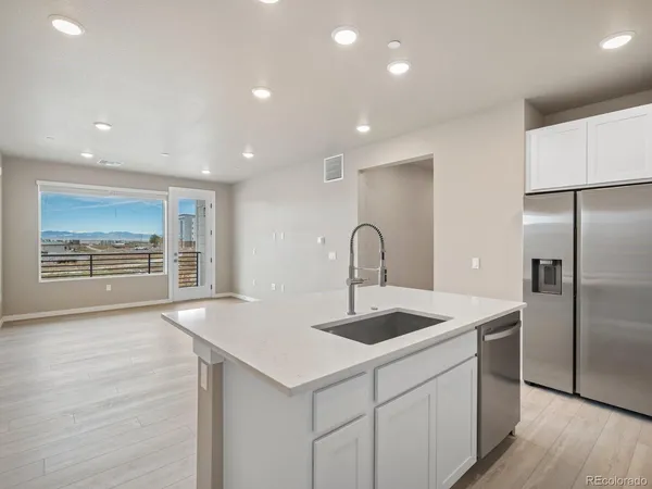 a kitchen with kitchen island a sink appliances and cabinets
