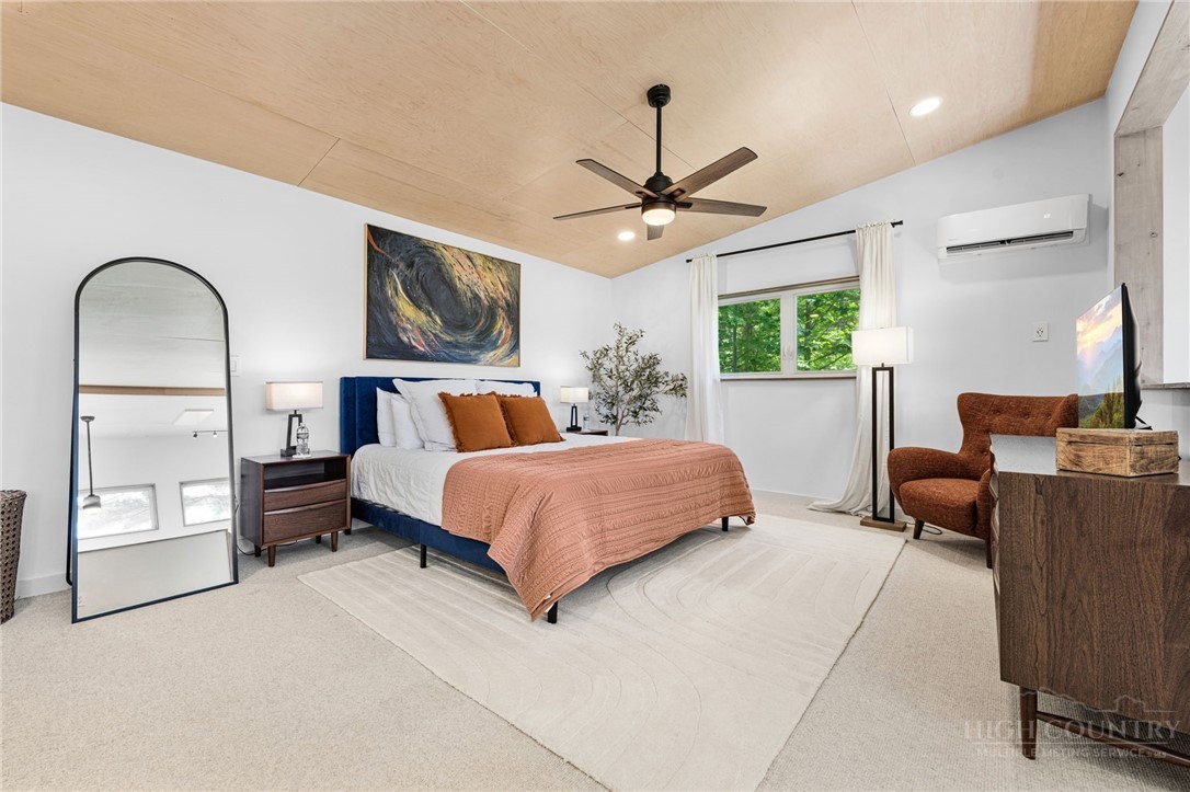 1385 Niley Cook Road Blowing Rock, NC 28605 - Photo 19 of 40 a bedroom with a large bed and a chandelier