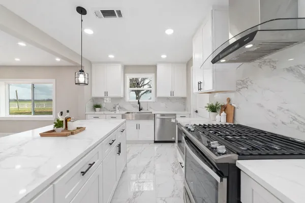 a kitchen with white cabinets and appliances