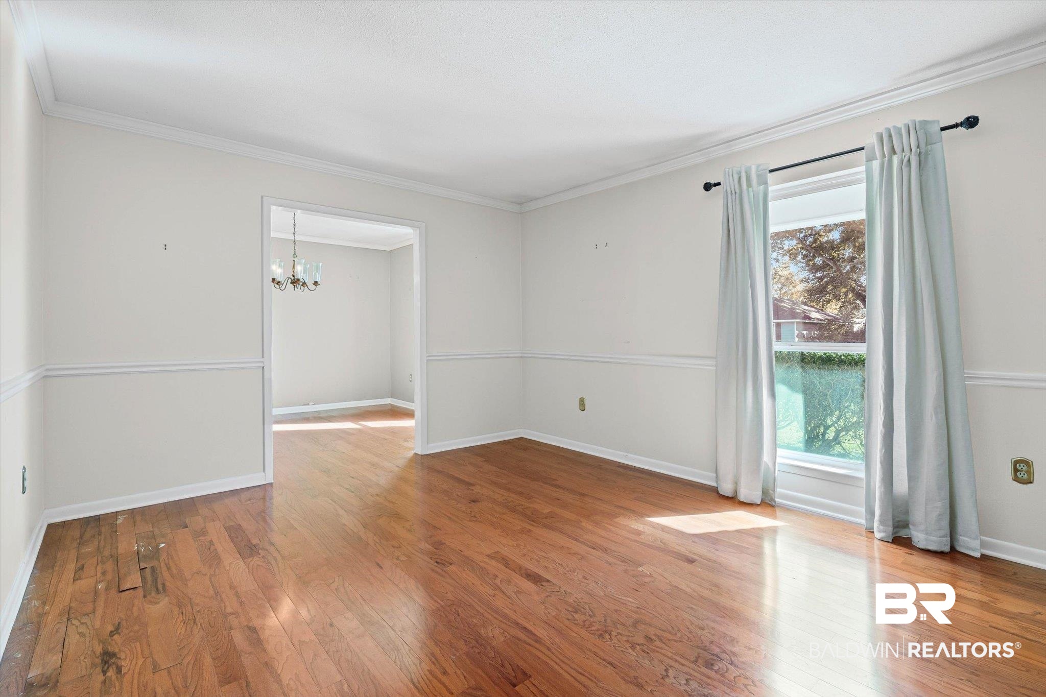 6300 Christopher Drive North Mobile, AL 36609 - Photo 3 of 22 Unfurnished room with ornamental molding, light wood-style flooring, and a chandelier