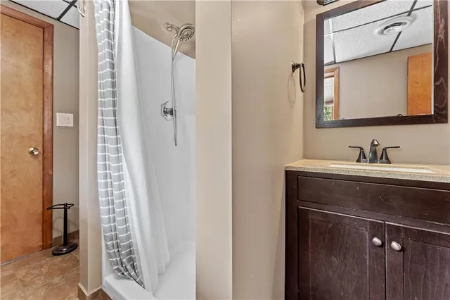 a bathroom with a shower a sink and a mirror