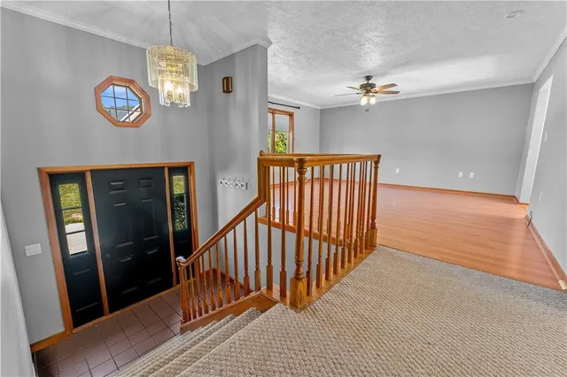 a view of a hallway with wooden floor and a chandelier