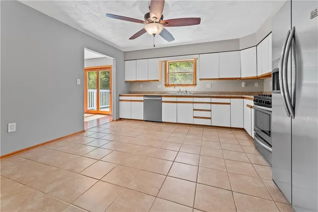 a large kitchen with a stove a sink dishwasher and a refrigerator