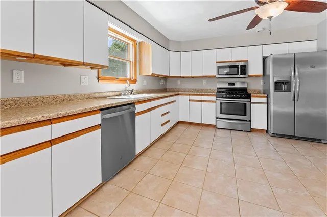a kitchen with stainless steel appliances granite countertop a refrigerator and a sink