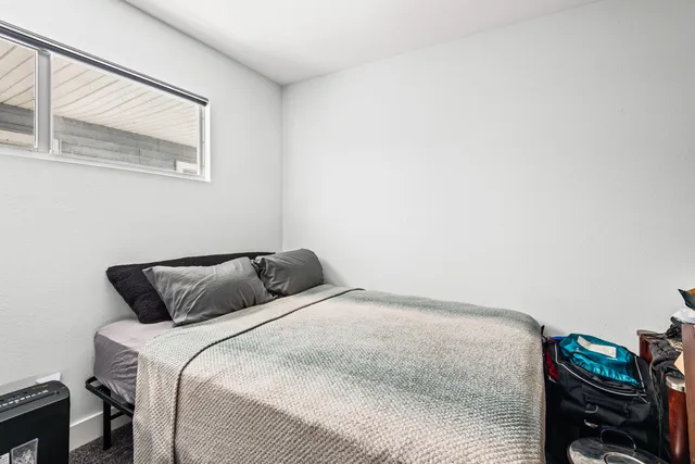 a bedroom with a bed and a window