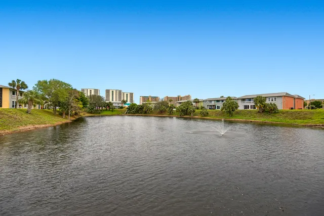 a view of an ocean with boats and trees in the background