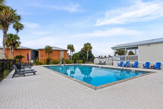 an outdoor patio with swimming pool and furniture